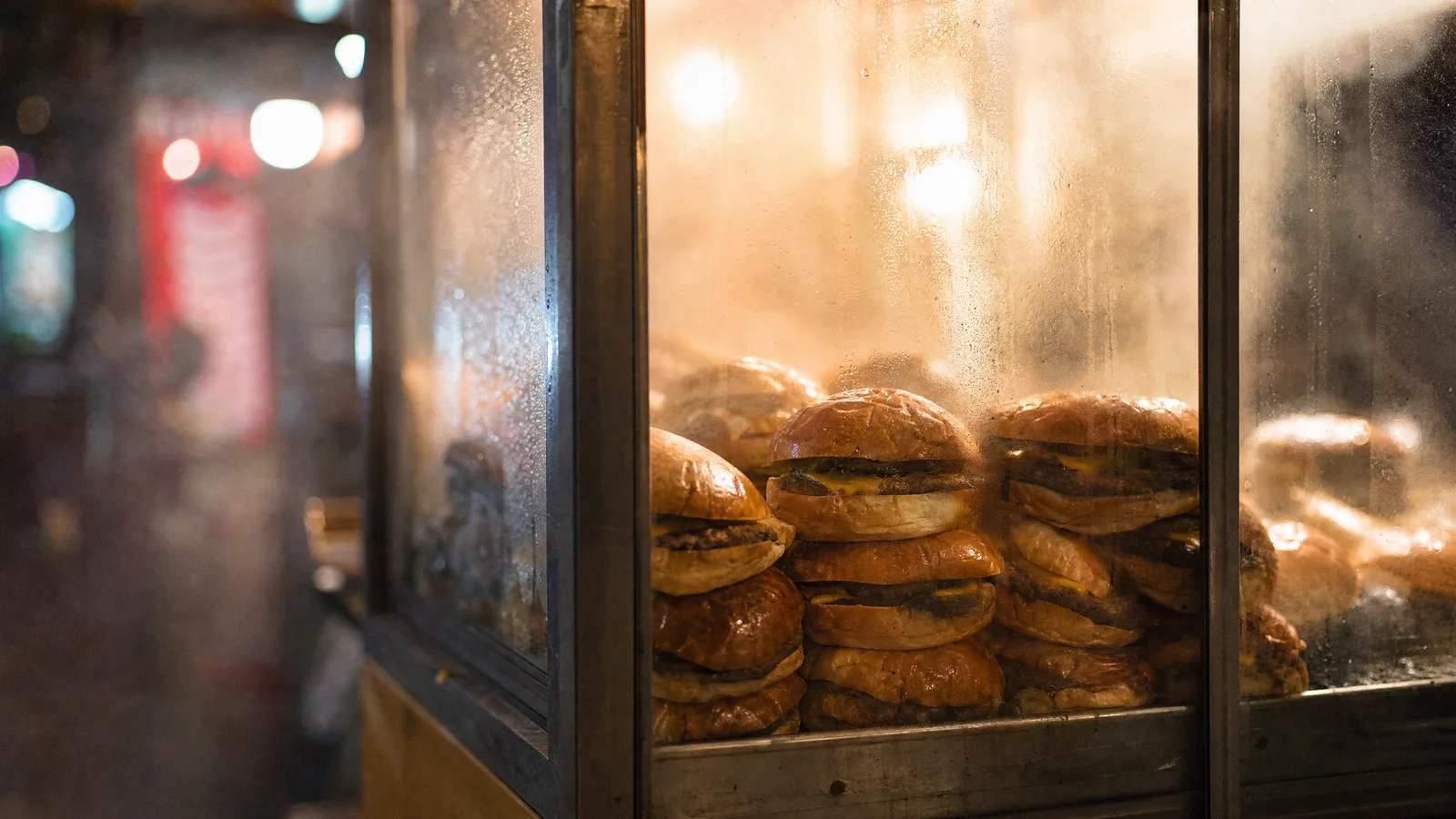Buharlı cam dolapta üst üste dizilmiş ıslak burgerler